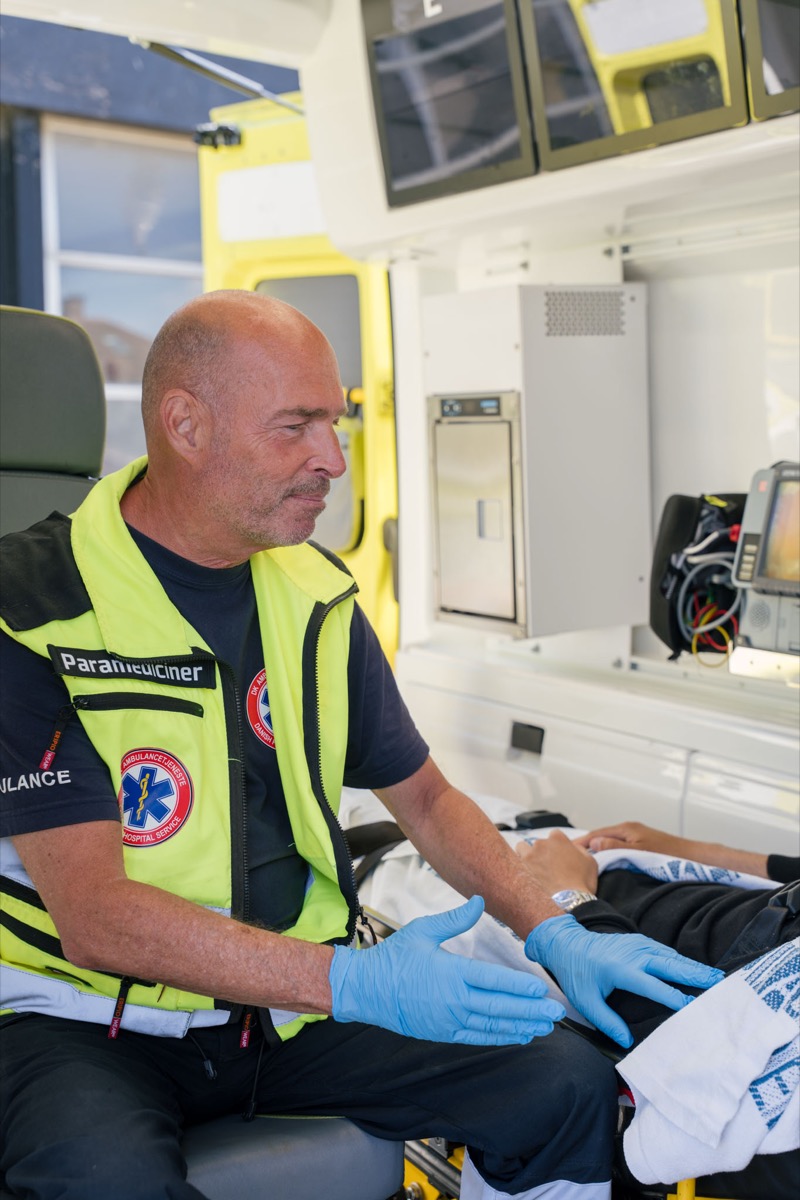 Paramediciner tilser en patient inde i ambulancen