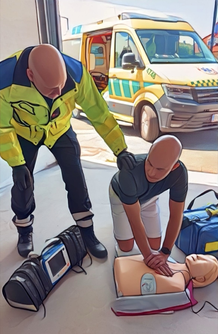 Instruktør og deltager træner realistiske cases med ambulance i baggrunden